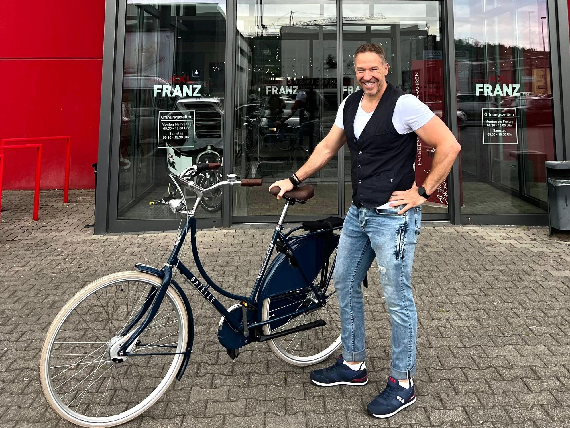 Patrick Lück steht mit dem Fahrrad in Köln.