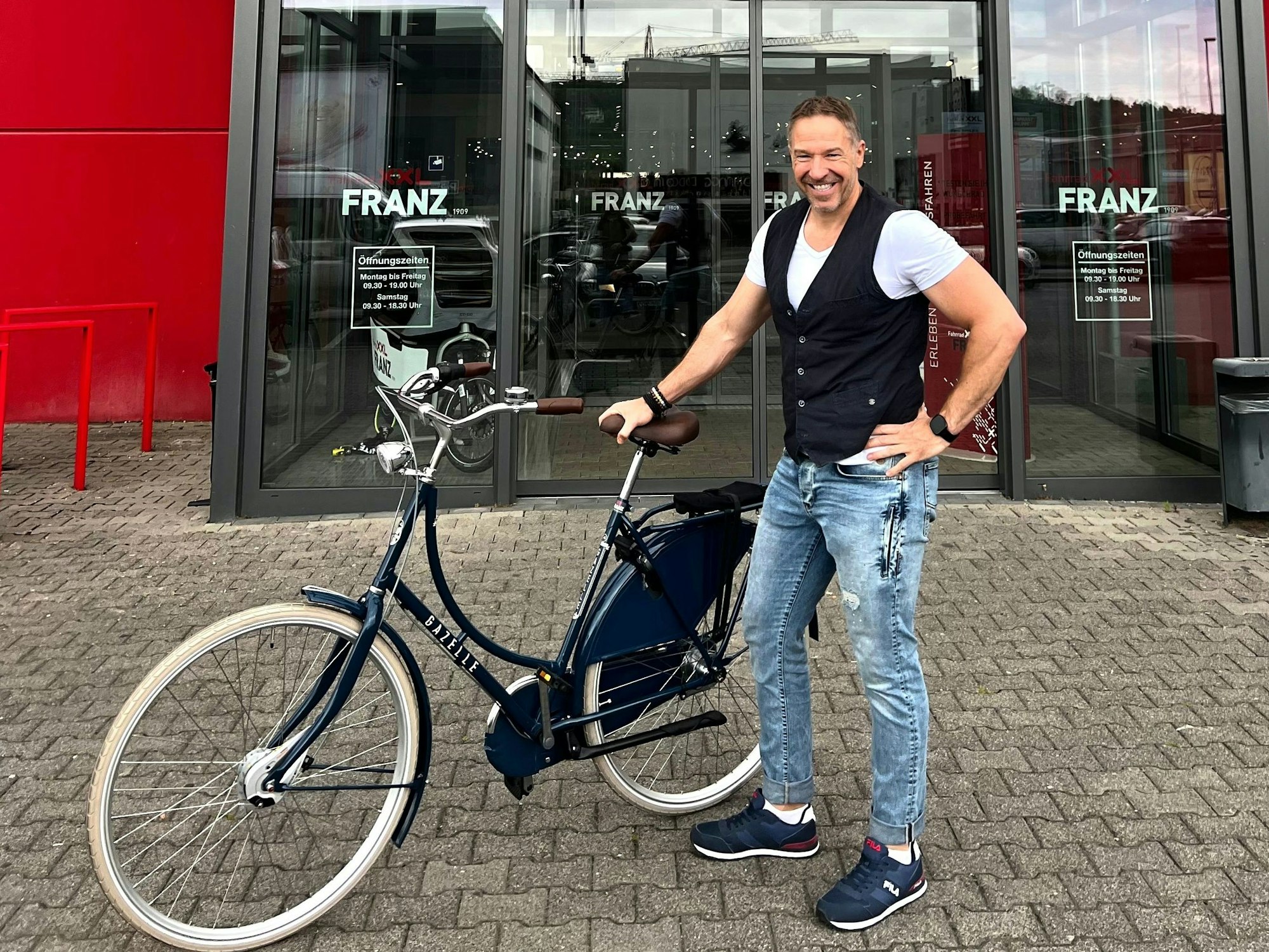 Patrick Lück steht mit dem Fahrrad in Köln.
