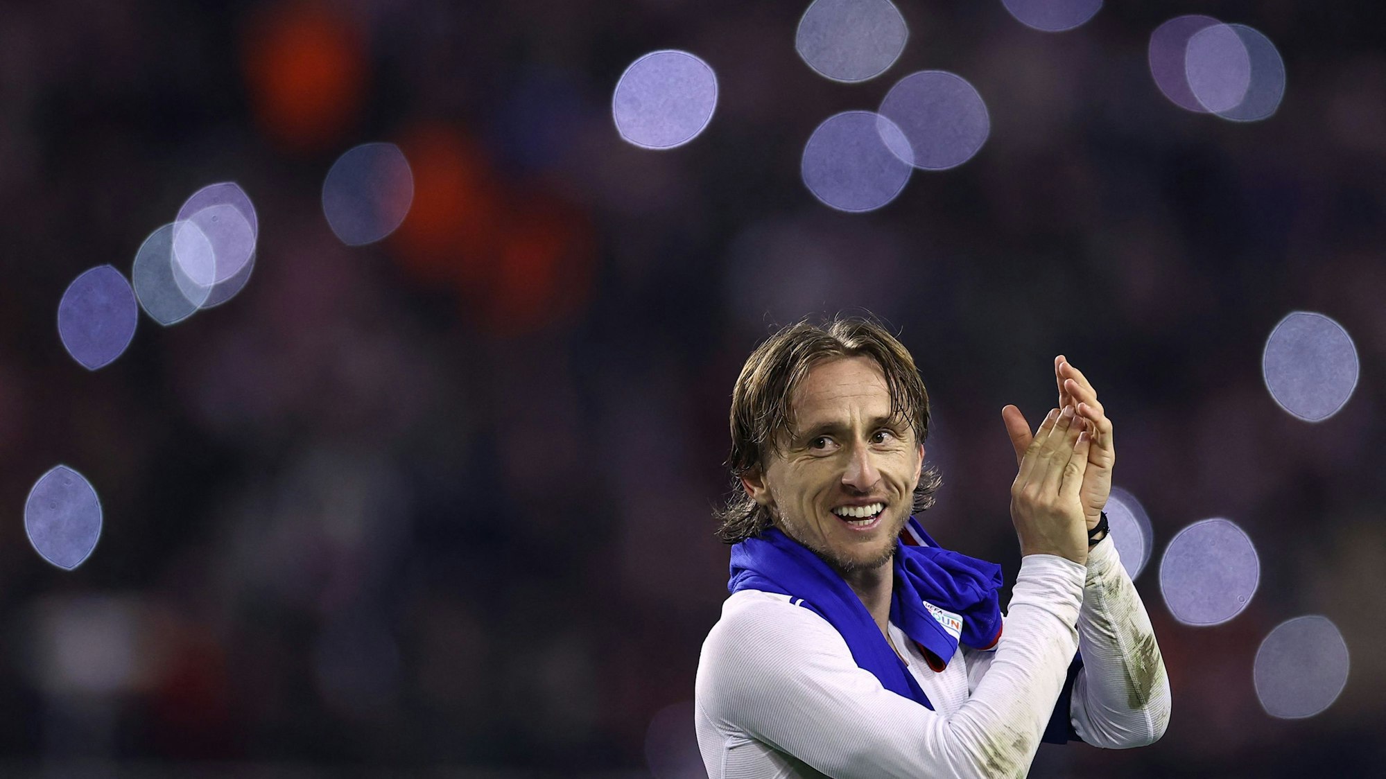 Luka Modric klatscht lächelnd den Fans zu.