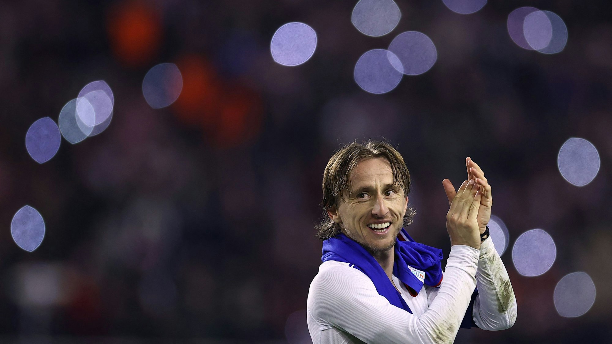 Luka Modric klatscht lächelnd den Fans zu.