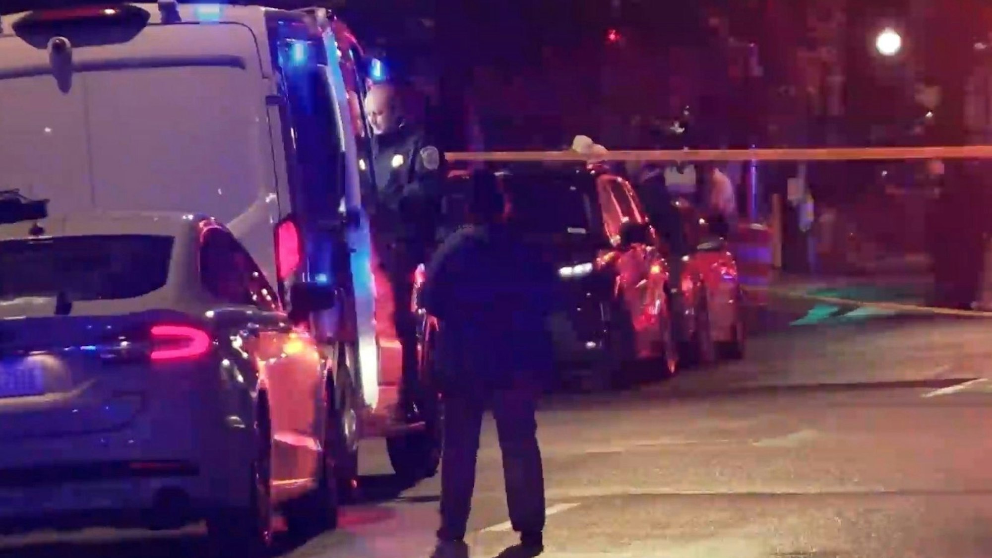 Auf diesem Bild aus einem von WJLA zur Verfügung gestellten Video sieht eine Person zu, wie die Strafverfolgungsbehörden den Tatort untersuchen, nachdem zwei Mitarbeiter der israelischen Botschaft in Washington vor dem Capital Jewish Museum getötet wurden.