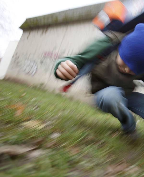 Unter Schülern kommt es immer mehr zu brutalen Übergriffen. Ein Schüler drückt auf dem Schulhof eines Gymnasiums einen anderen Schüler zu Boden (gestelltes Illustrationsfoto).