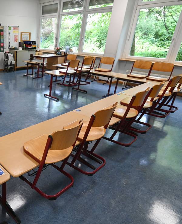 Stühle stehen in einem leeren Klassenzimmer. An mehreren Schulen in NRW sind am Freitag Drohmails eingegangen (Symbolbild).