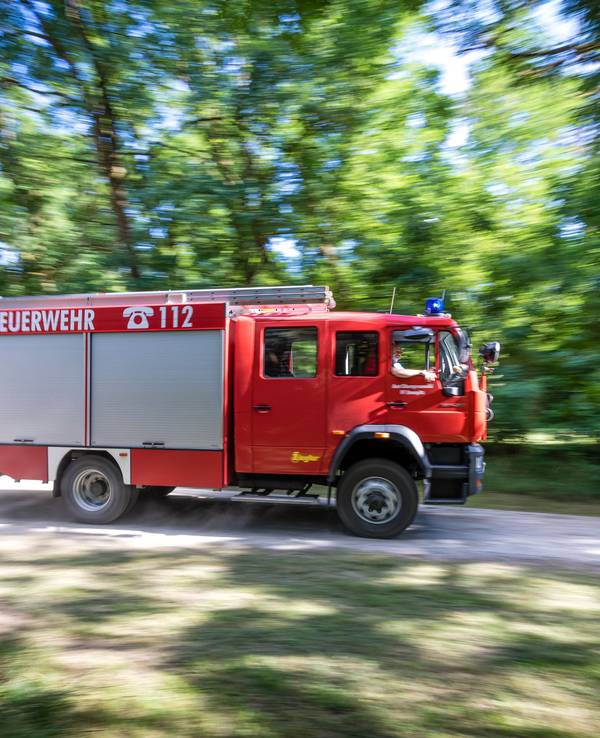 Ein Fahrzeug der Feuerwehr fährt in Brandenburg durch den Wald.
