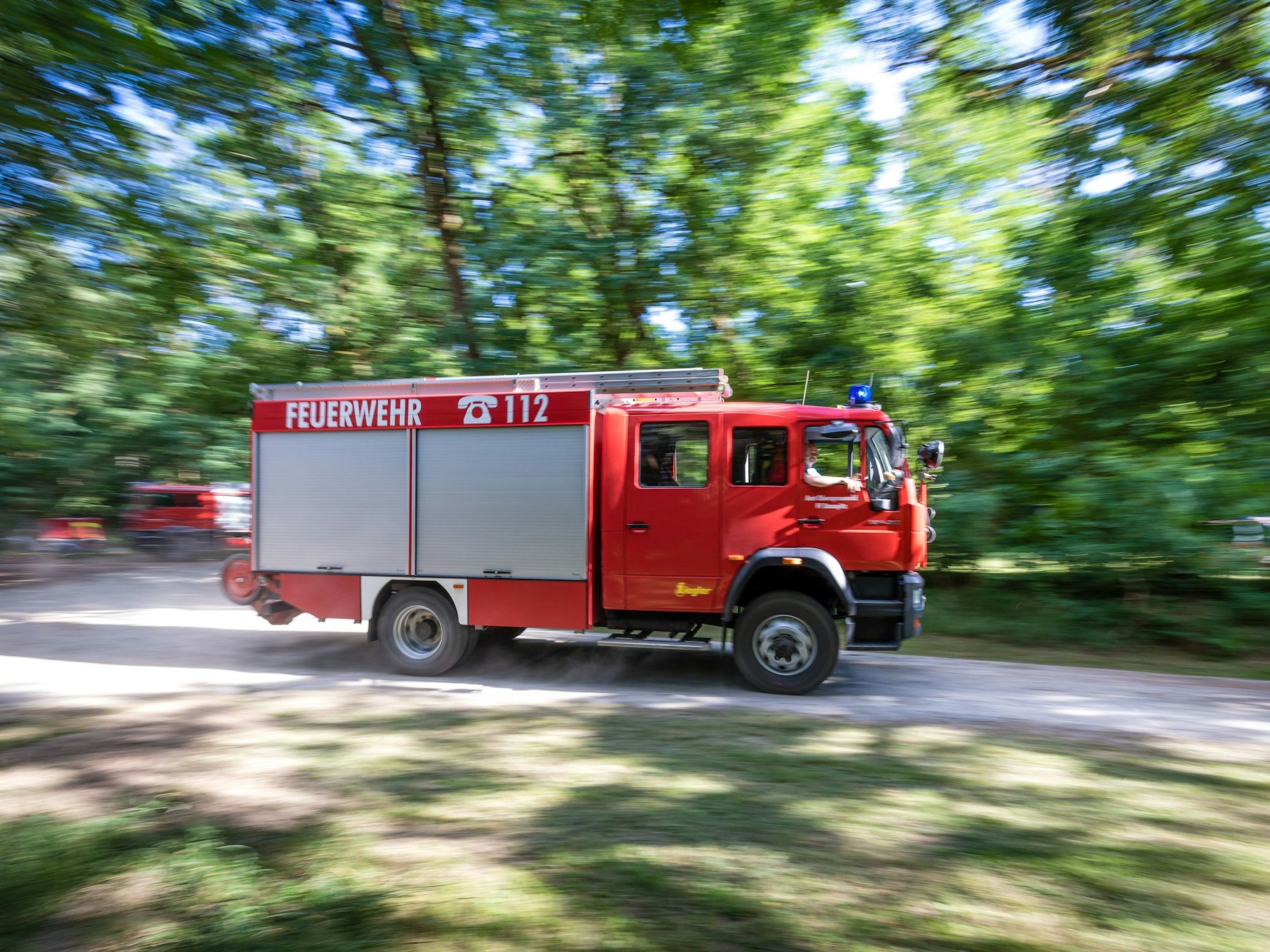 Ein Fahrzeug der Feuerwehr fährt in Brandenburg durch den Wald.