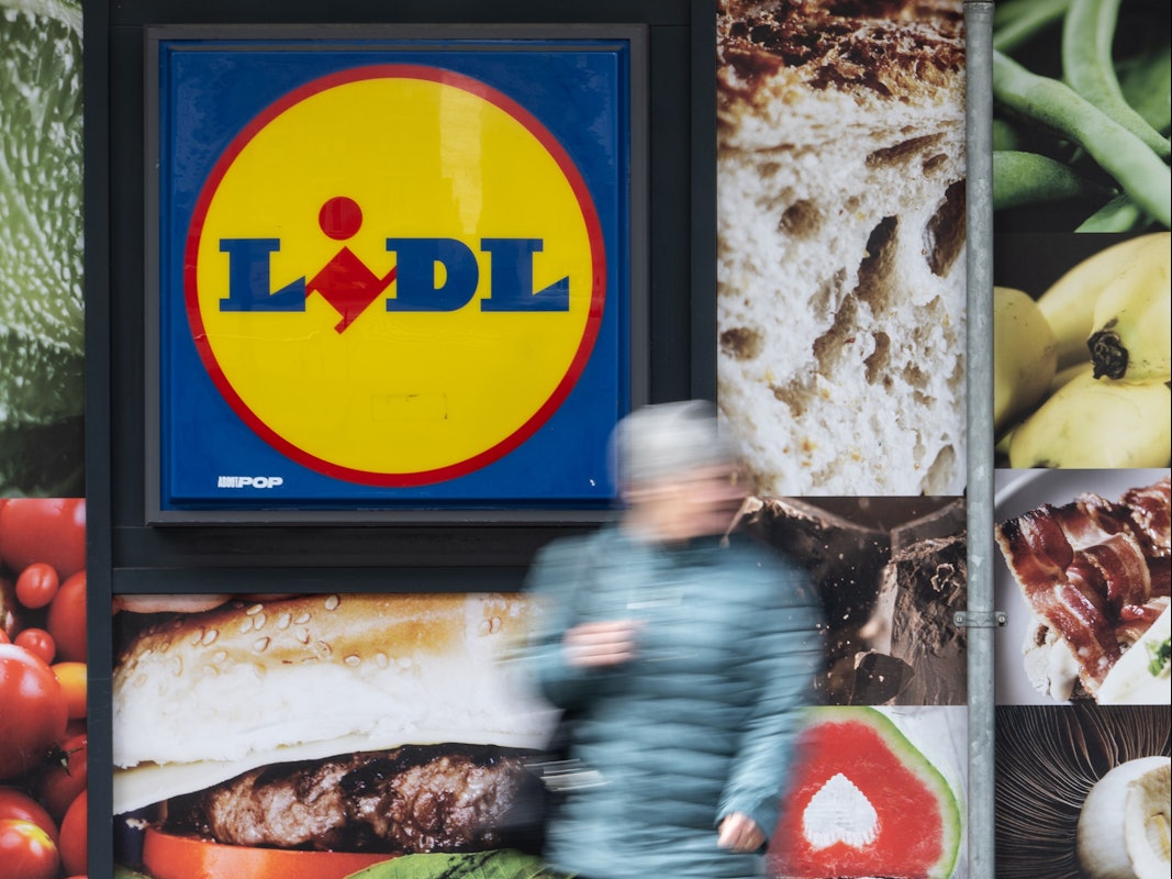 Eine Passantin geht an der Außenwerbung einer Lidl-Filiale vorbei. Der Discounter kündigt „historische Preisnachlässe“ an.