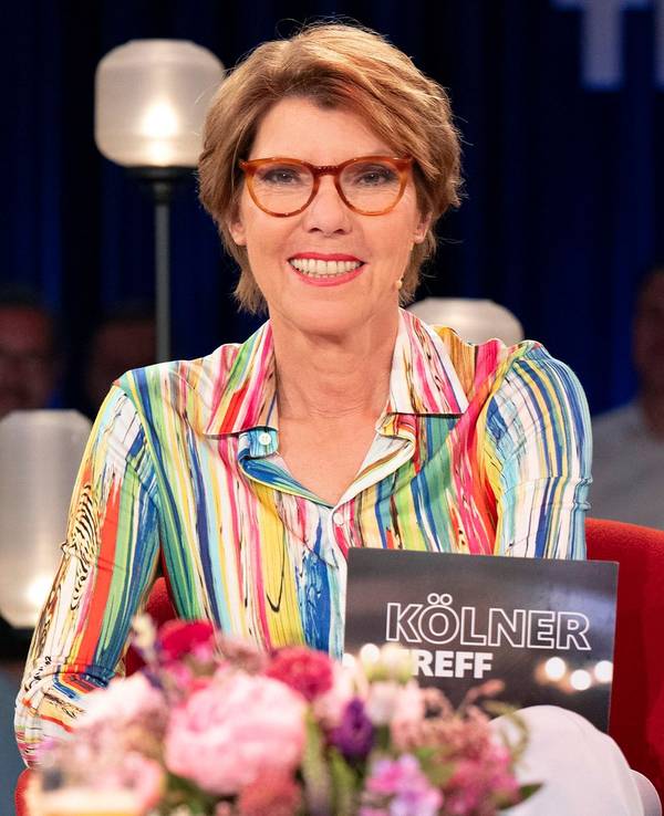 Eine Frau sitzt auf einem Sessel in einem TV-Studio.