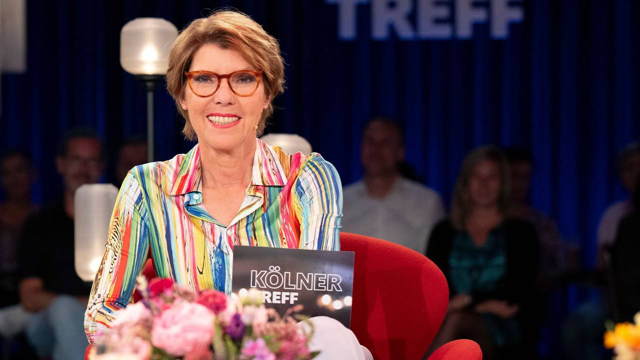 Eine Frau sitzt auf einem Sessel in einem TV-Studio.