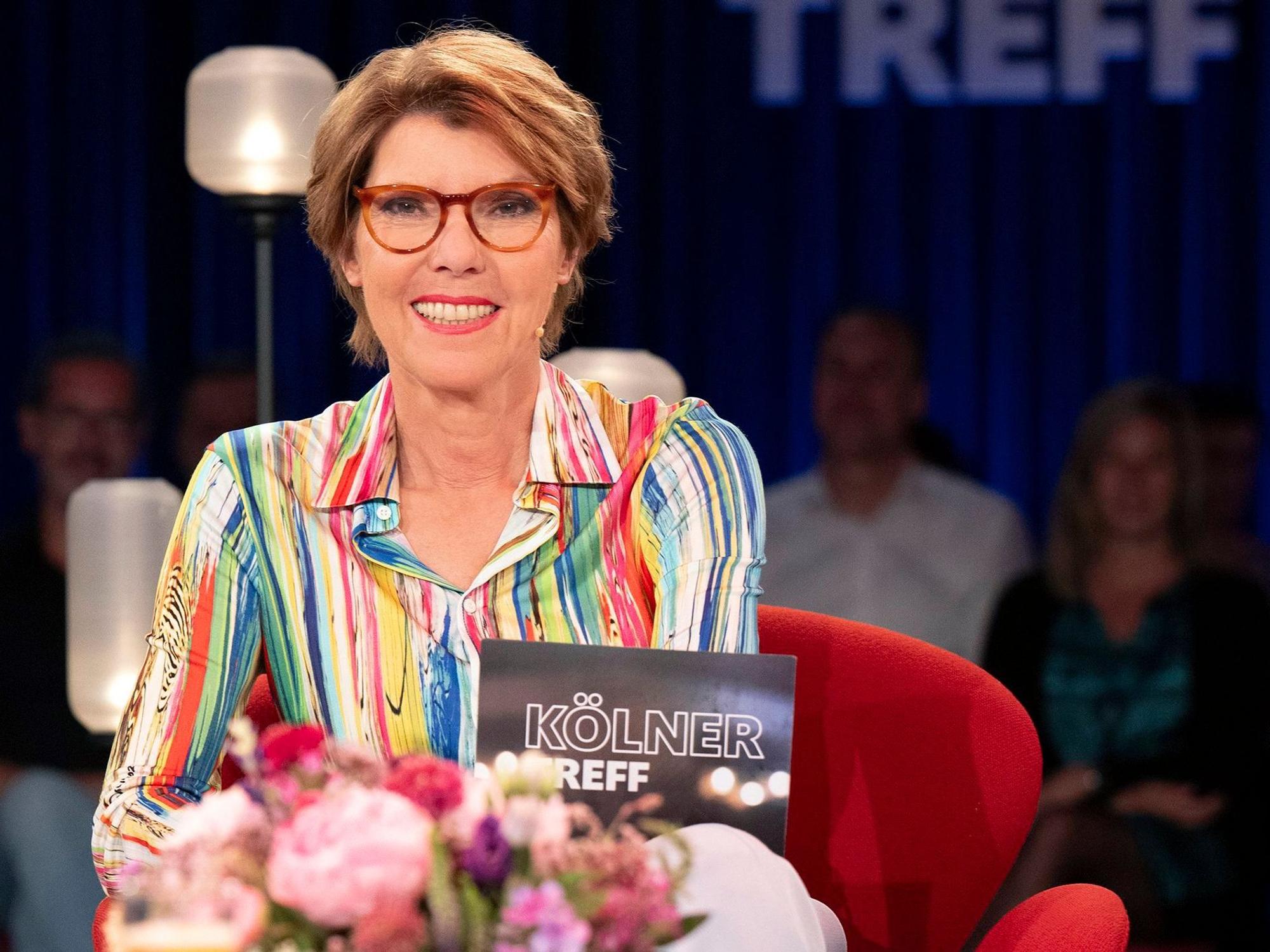 Eine Frau sitzt auf einem Sessel in einem TV-Studio.