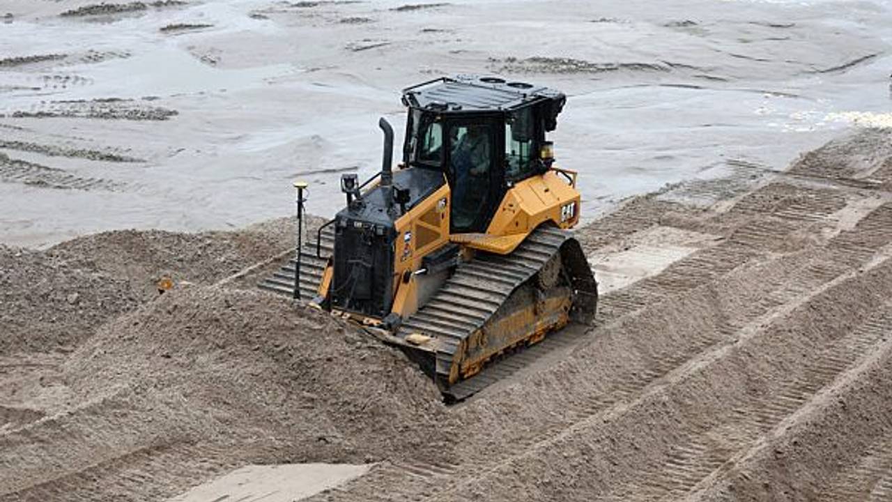 Eine Planierraupe verteilt im Dezember 2022 am Ostseestrand im Kreis Rostock Sand.