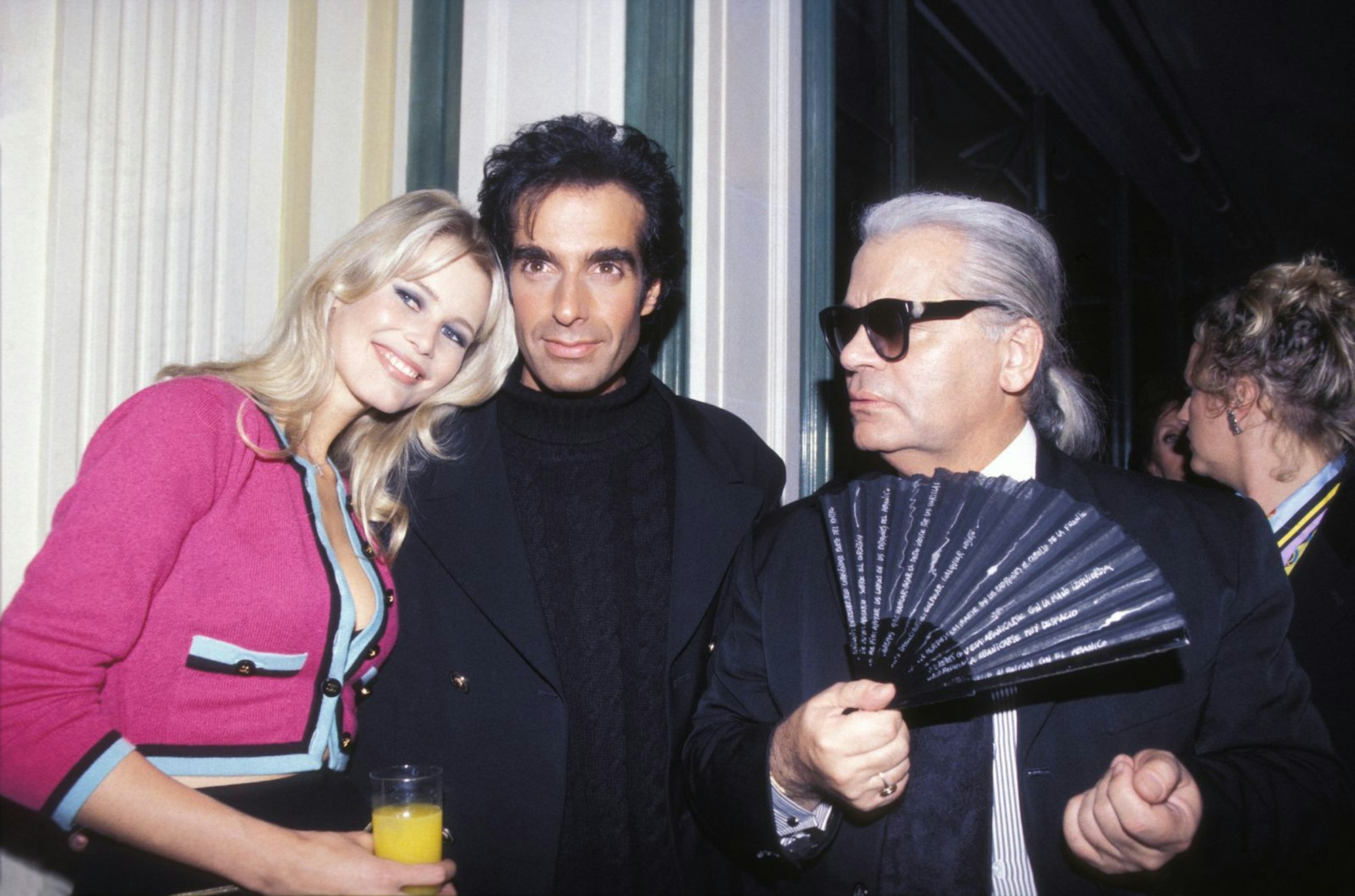 Karl Lagerfeld sah in den 1990-ern in Claudia Schiffer seine Muse. Hier ist er mit Schiffer und Magier David Copperfield auf einer Party 1994 in Paris zu sehen. (Bild: ARNAL/PICOT/Gamma-Rapho via Getty Images)