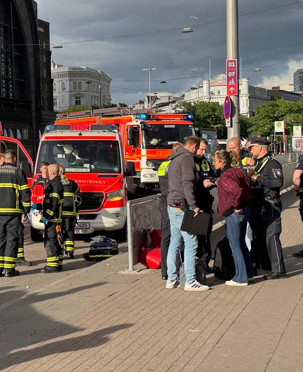 Nach der Messerattacke am Hamburger Hauptbahnhof stehen Einsatzkräfte von Rettungsdienst und Feuerwehr am 23. Mai 2025 vor dem Gebäude.