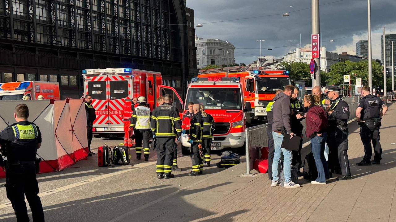 Nach der Messerattacke am Hamburger Hauptbahnhof stehen Einsatzkräfte von Rettungsdienst und Feuerwehr am 23. Mai 2025 vor dem Gebäude.