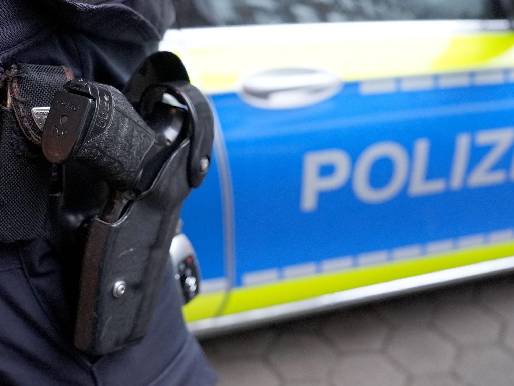Ein Polizist mit einer Waffe im Einsatz. (Symbolfoto)