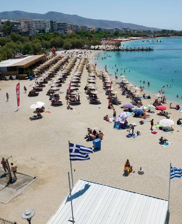 Menschen verbringen den Tag an einem Strand im Vorort Alimos in Athen. Besonders deutsche Touristen und Touristinnen lieben Griechenland.