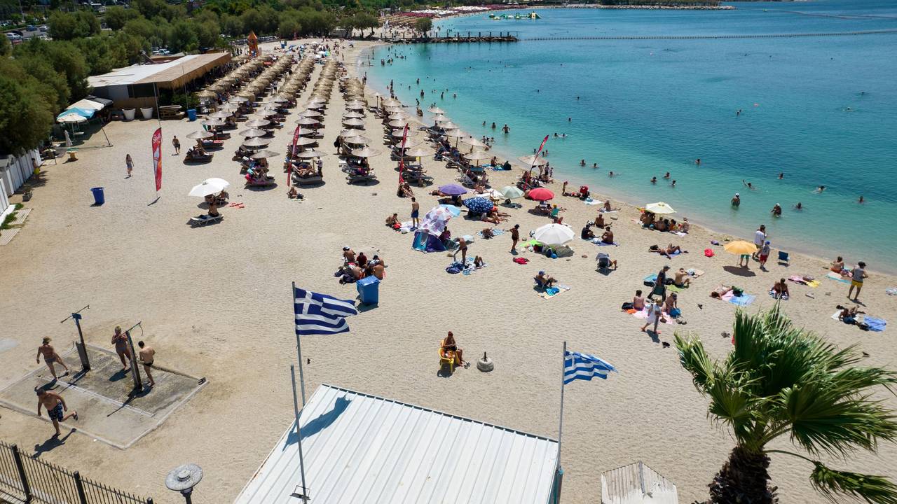 Menschen verbringen den Tag an einem Strand im Vorort Alimos in Athen. Besonders deutsche Touristen und Touristinnen lieben Griechenland.