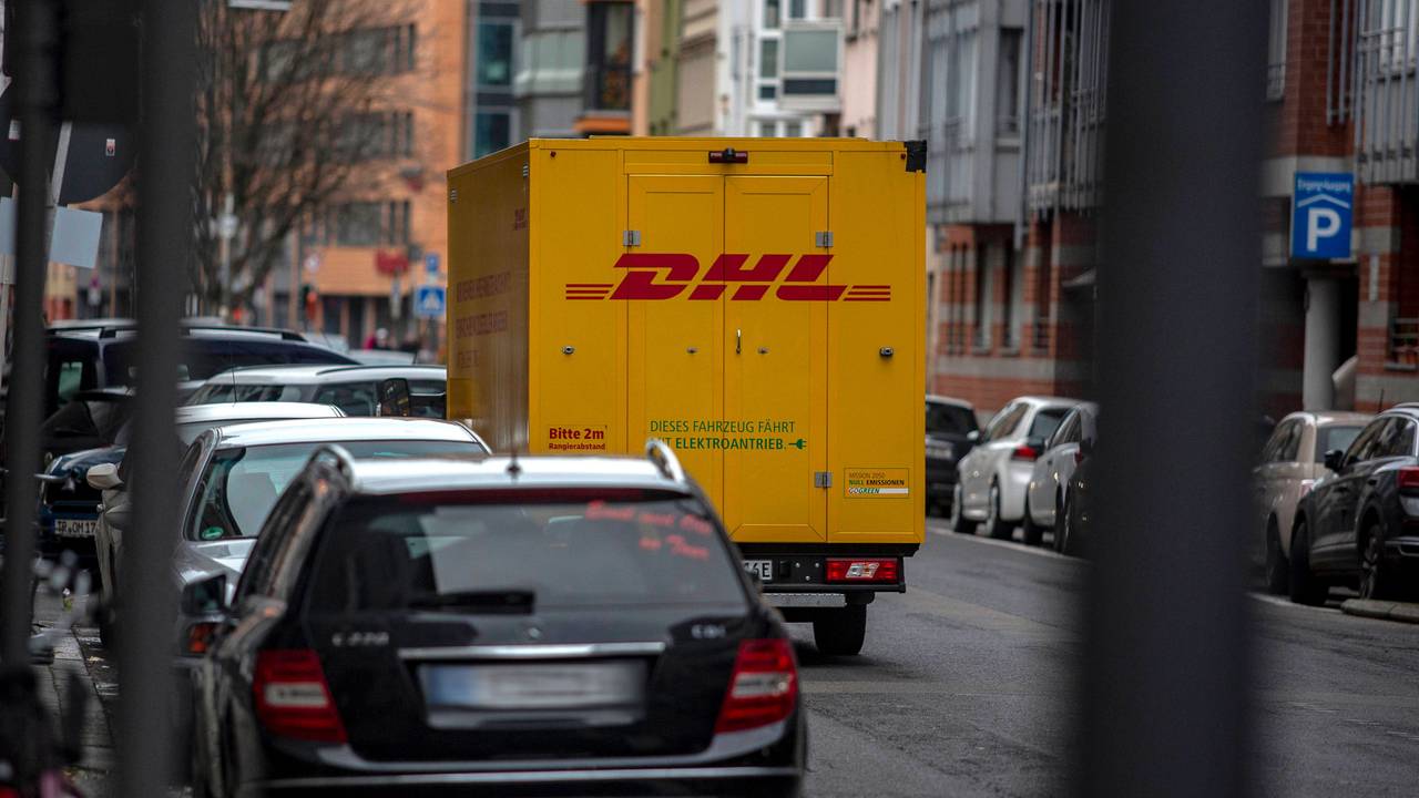Ein DHL-Zustellfahrzeug steht in Köln auf der Straße.