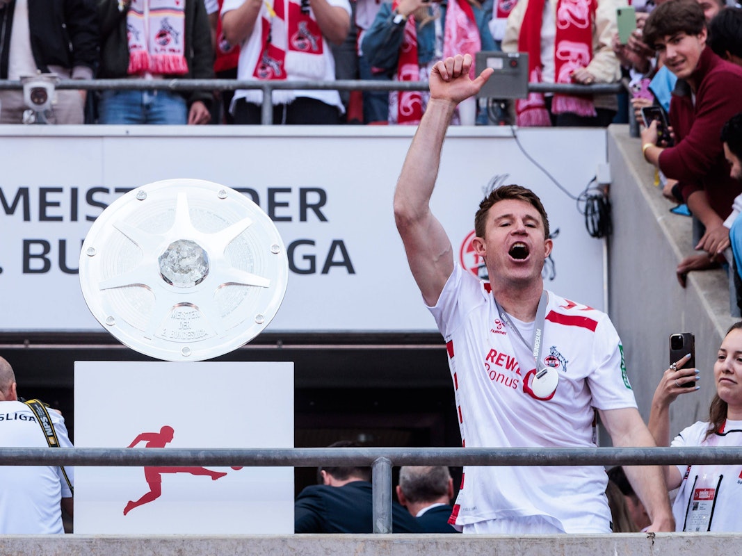 Dominique Heintz (1. FC Köln) feiert neben der Schale den Aufstieg im Rhein-Energie-Stadion.