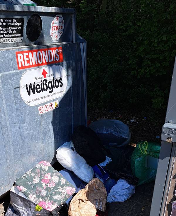 Müll liegt neben den Containern in Köln-Zündorf in der Houdainer Straße.