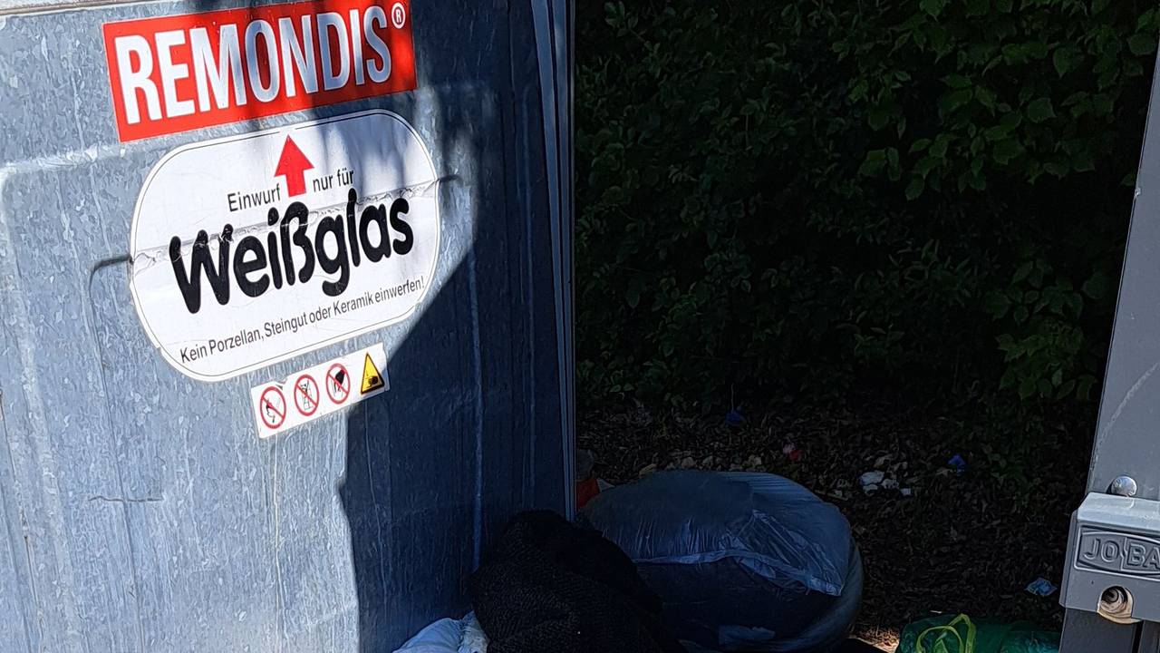 Müll liegt neben den Containern in Köln-Zündorf in der Houdainer Straße.