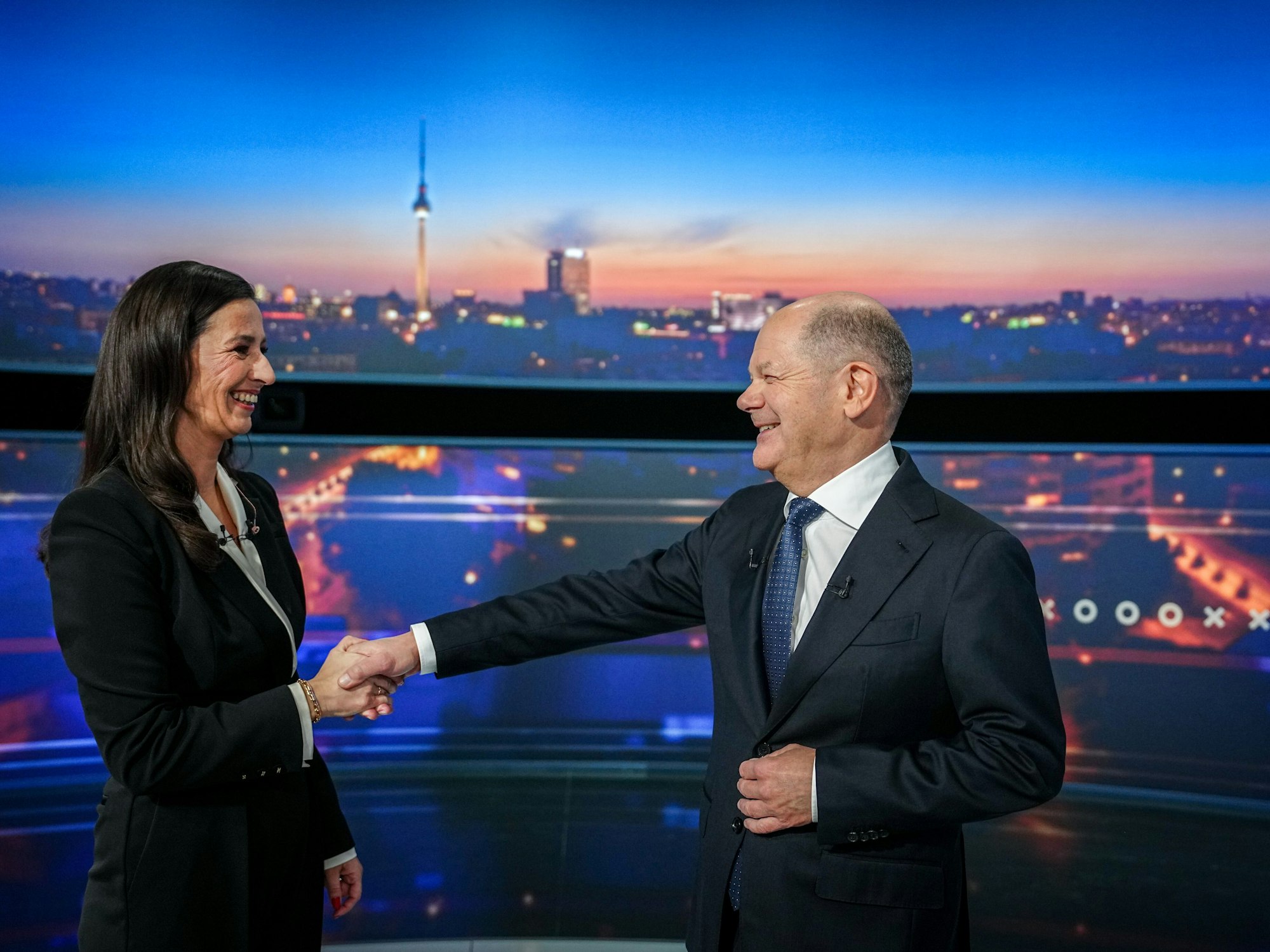 Pinar Atalay und der damalige Bundeskanzler Olaf Scholz begrüßen sich vor dem RTL-„Quadrell“ 2025.