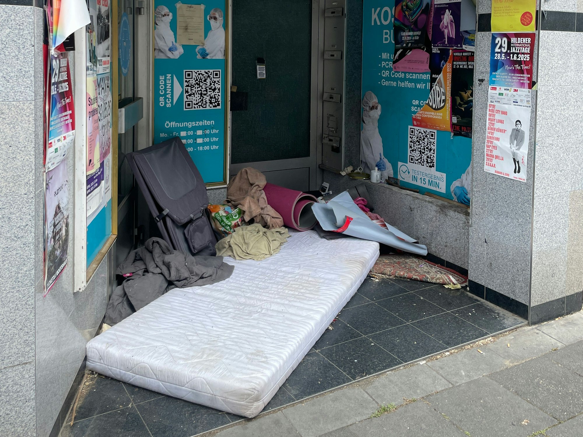 In einem Hauseingang liegt eine Matratze.