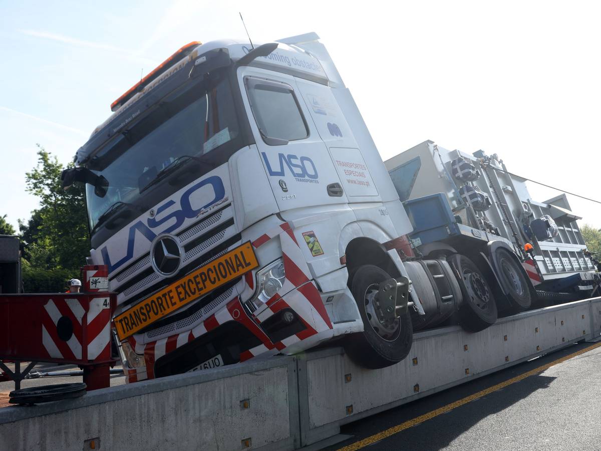 Ein Lkw hängt halb auf einer niedrigen Mauer.