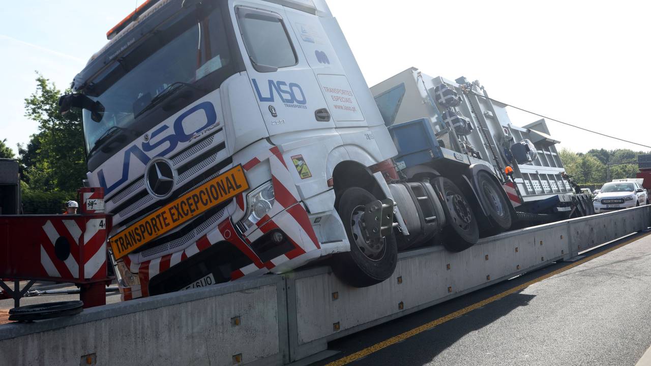 Ein Lkw hängt halb auf einer niedrigen Mauer.