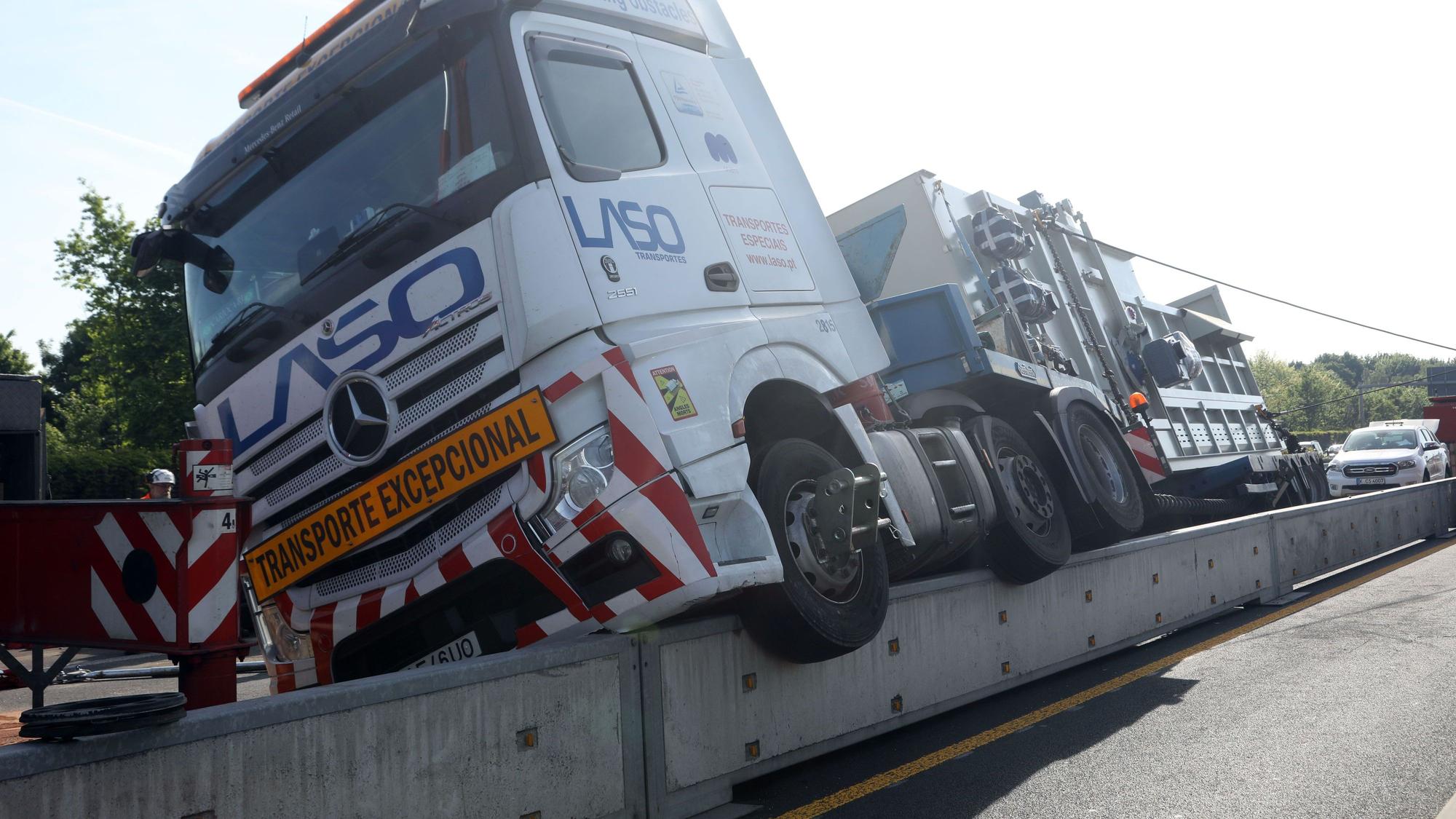 Ein Lkw hängt halb auf einer niedrigen Mauer.
