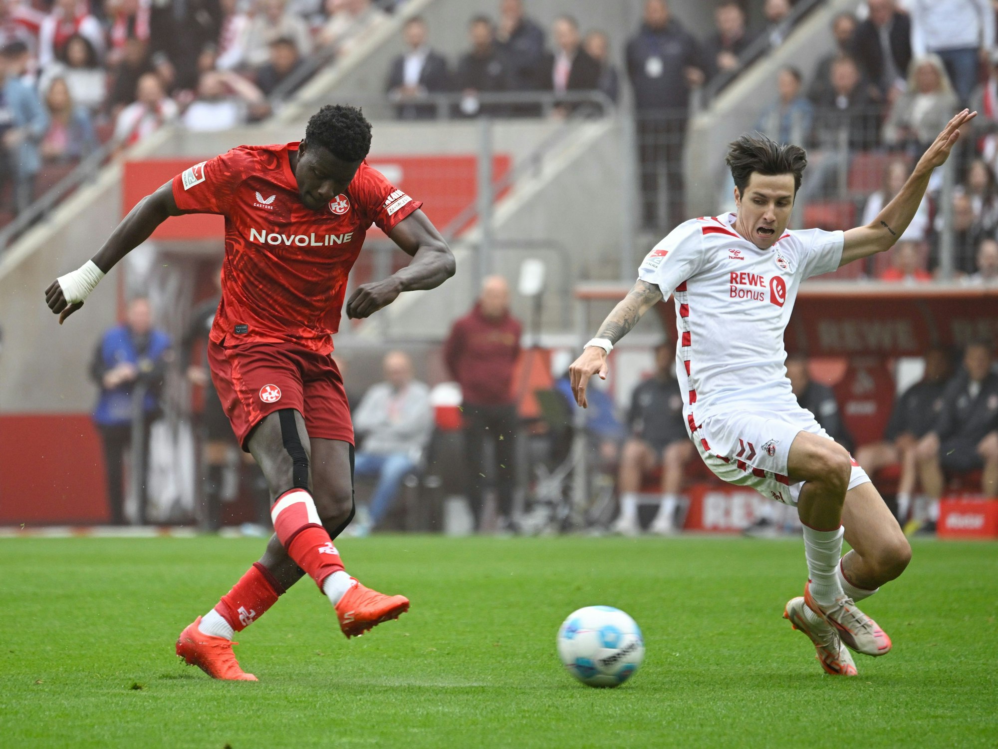 Kaiserslauterns Ragnar Ache (l) und Kölns Denis Huseinbasic kämpfen um den Ball.