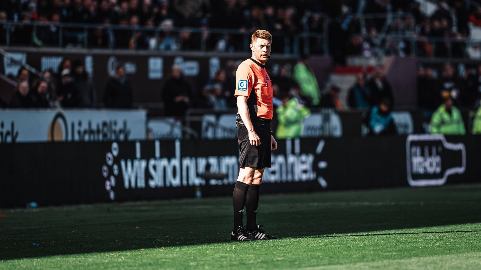 Schiedsrichter Christian Dingert bei einer Stadion-Durchsage