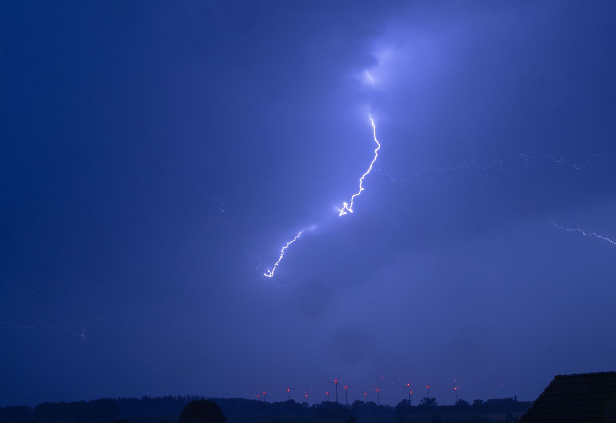 Ein Blitz ist bei einem starken Gewitter über einer Windkraftanlage in Mecklenburg-Vorpommern zu sehen (Archivbild 2019).
