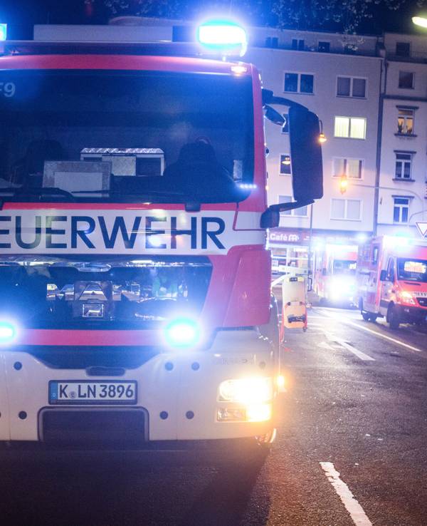 Ein Feuerwehrmann steht neben einem Feuerwehrauto.