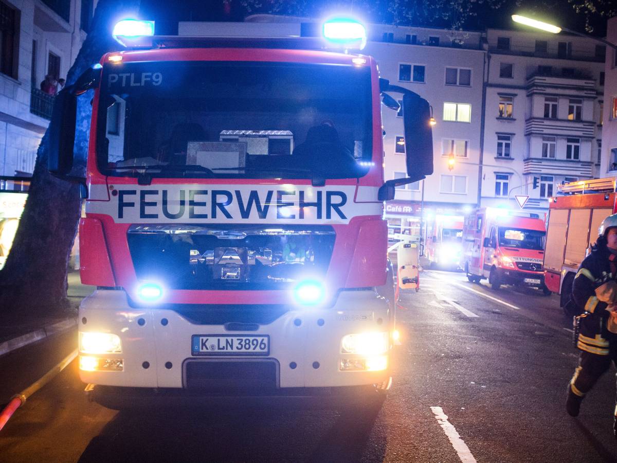 Ein Feuerwehrmann steht neben einem Feuerwehrauto.