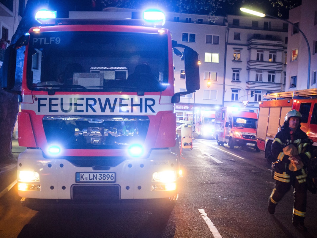Ein Feuerwehrmann steht neben einem Feuerwehrauto.