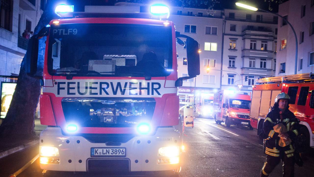 Ein Feuerwehrmann steht neben einem Feuerwehrauto.