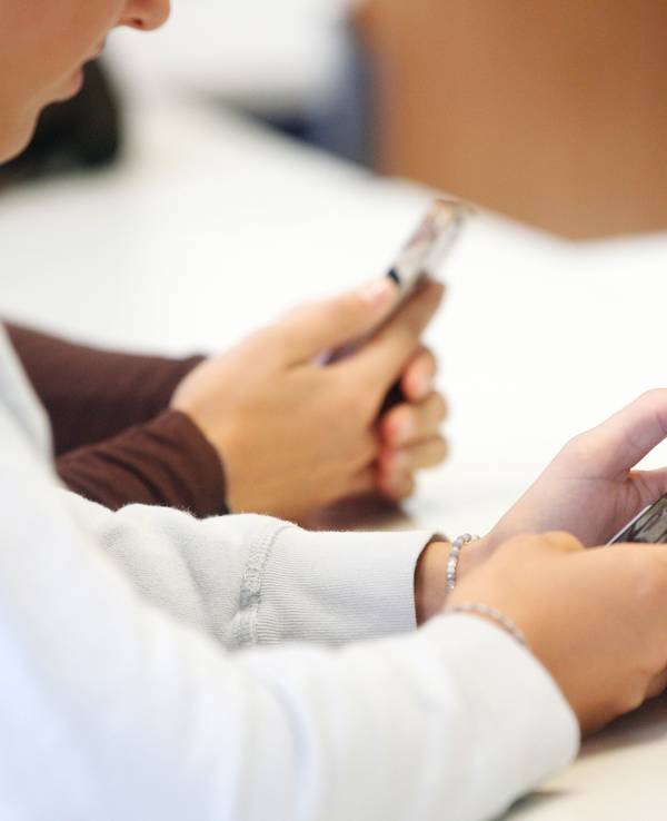 Schüler benutzen ihr Smartphone im Unterricht. Die Geräte müssen laut Ökodesign-Verordnung etwa nach 800 Ladezyklen noch eine Akku-Restkapazität von 80 Prozent aufweisen. Hersteller müssen zudem sieben Jahre nach Verkaufsstopps eines Modells noch Ersatzteile vorhalten und fünf Jahre lang die Betriebssysteme aktualisieren.