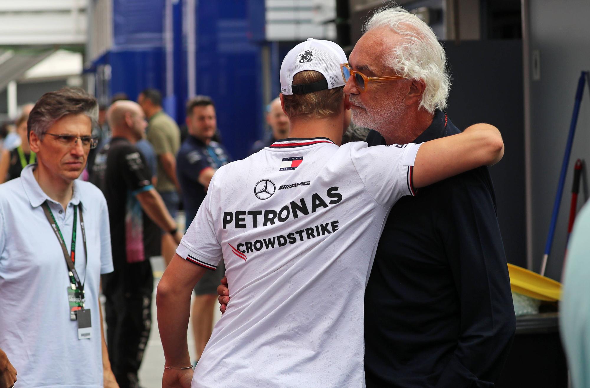 Mick Schumacher umarmt Flavio Briatore als Mercedes-Fahrer am Rande eines Rennens in Barcelona.