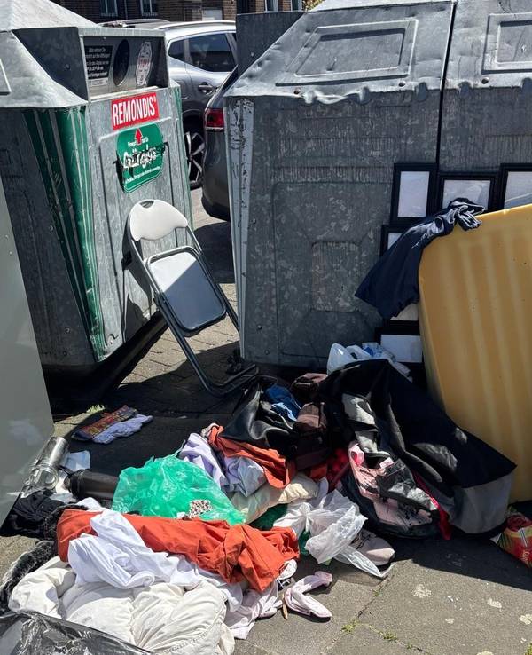 Textilen, eine Matratze und ein Klappstuhl wurden vor Containern entsorgt.