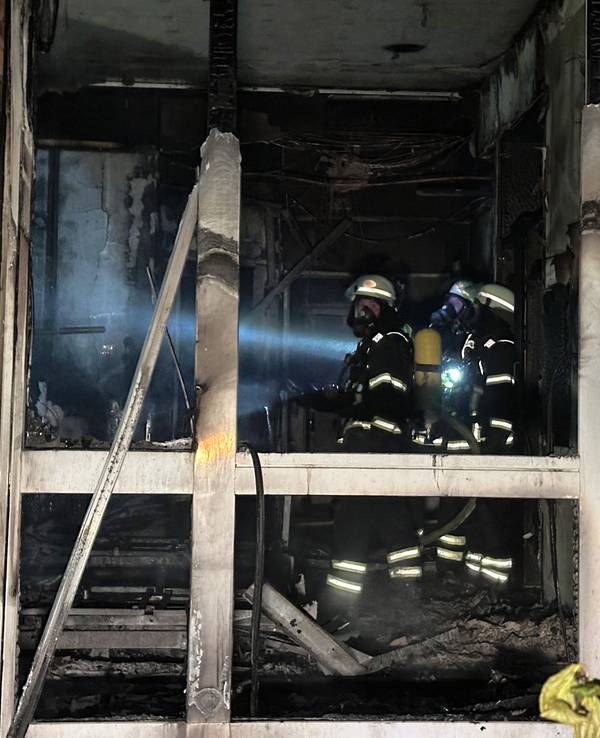 Feuerwehrleute mit Atemschutzgerät arbeiten in einem ausgebrannten Raum im Erdgeschoß im Marienkrankenhaus im Hamburger Stadtteil Hohenfelde.