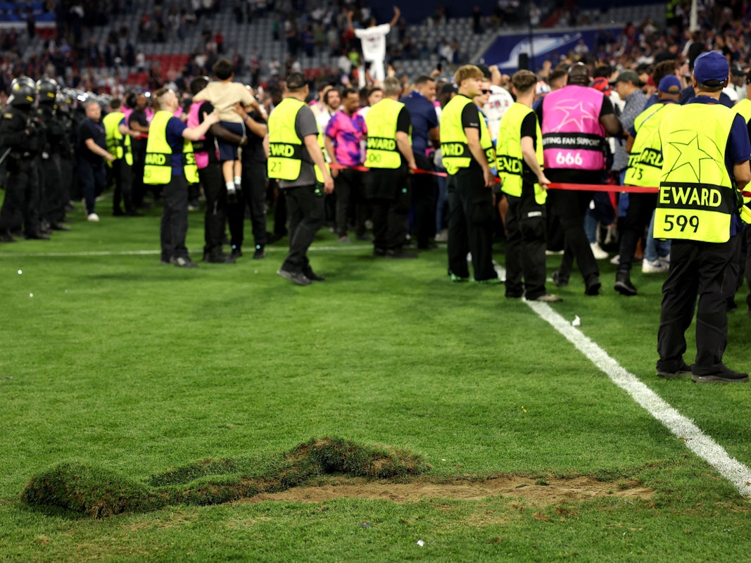 Ein großes Loch klafft nach dem Platzsturm der PSG-Fans im Rasen der Allianz-Arena. Im Hintergrund sind Ornder zu sehen.