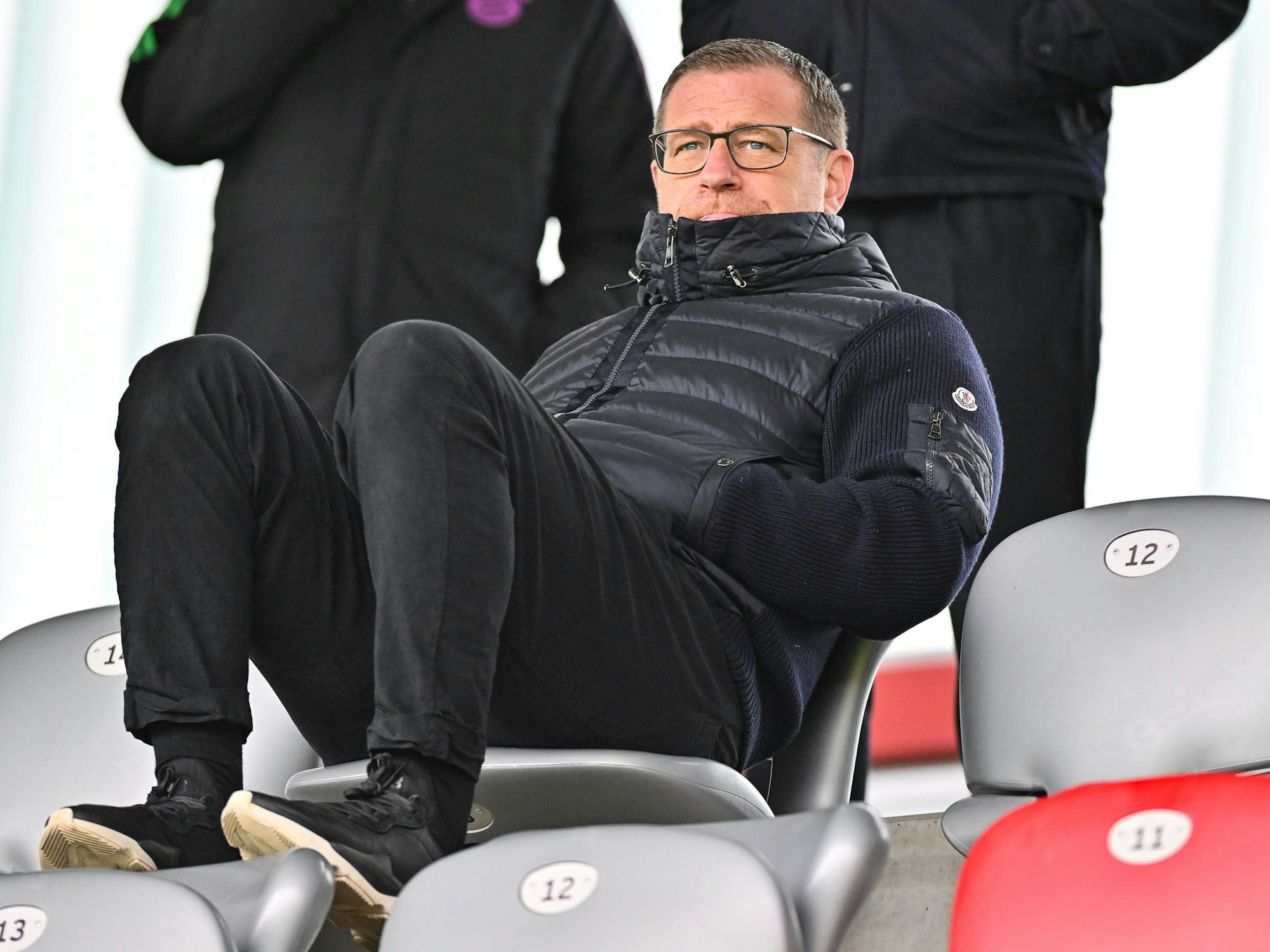 Max Eberl sitzt entspannt auf der Tribüne auf dem Campus des FC Bayern.
