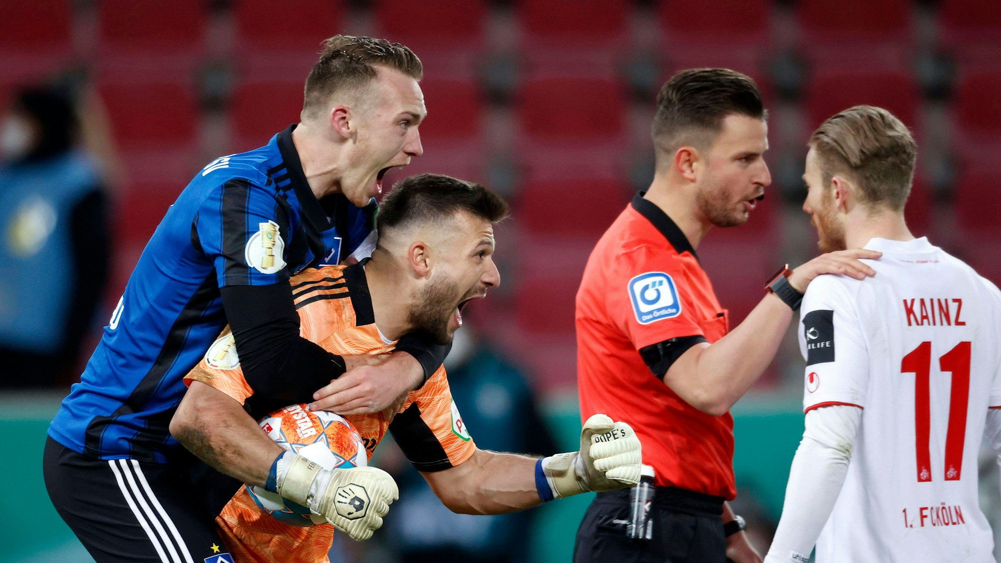 Der tragische Moment: Während FC-Profi Florian Kainz mit Schiedsrichter Daniel Schlager diskutierte, freuten sich die Spieler des Hamburger SV über den Einzug in das Viertelfinale des DFB-Pokals.
