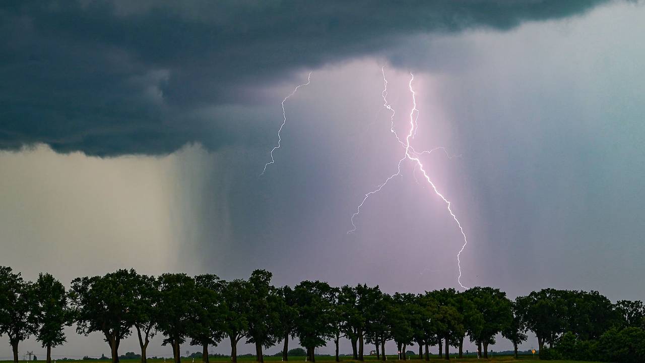 Ein Blitz leuchtet am späten Abend über der Landschaft.