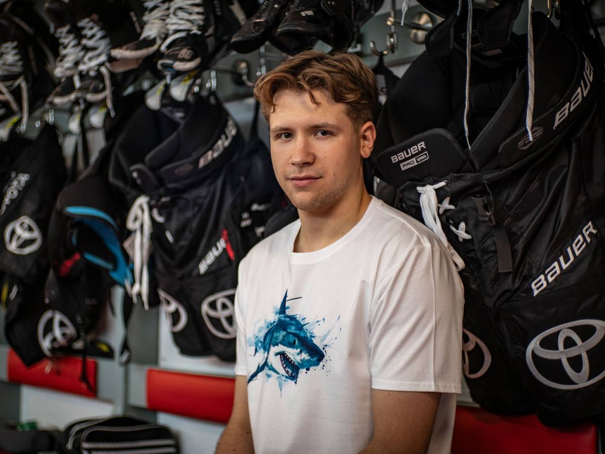 Sten Fischer sitzt im T-Shirt der Kölner Haie in der Kabine.