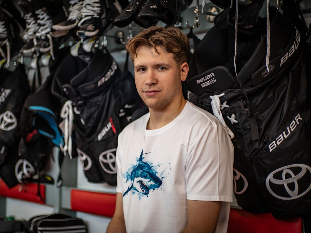 Sten Fischer sitzt im T-Shirt der Kölner Haie in der Kabine.