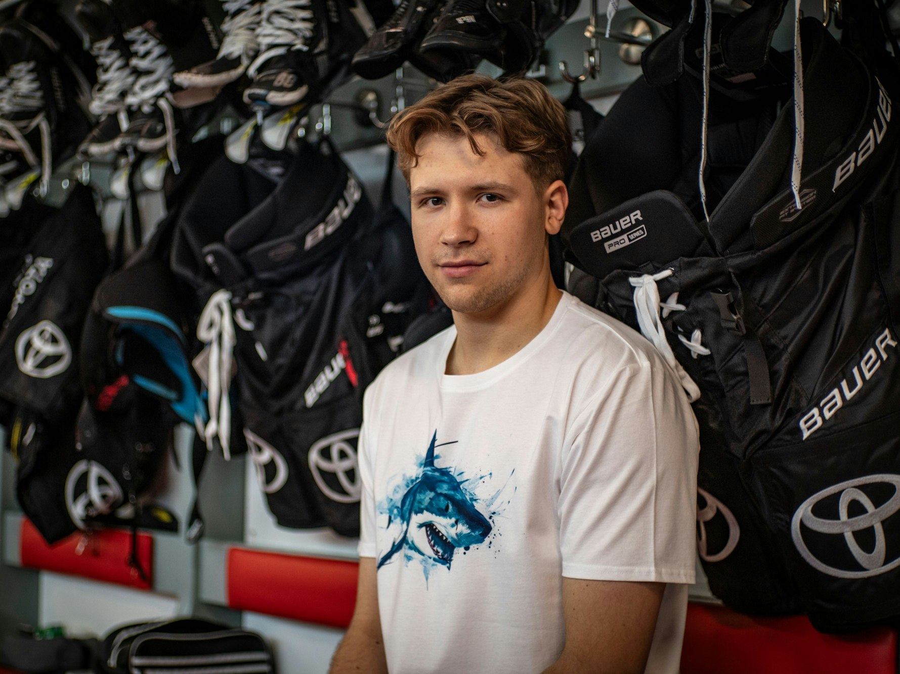 Sten Fischer sitzt im T-Shirt der Kölner Haie in der Kabine.