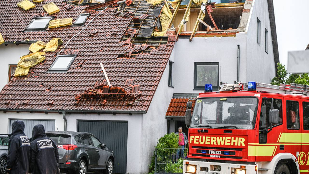 Einsatzkräfte von Feuerwehr und Polizei sind am 4. Juni im Ulmer Stadtteil Donaustetten im Einsatz, nachdem durch das Unwetter das Dach eines Reihenhauses stark beschädigt wurde.