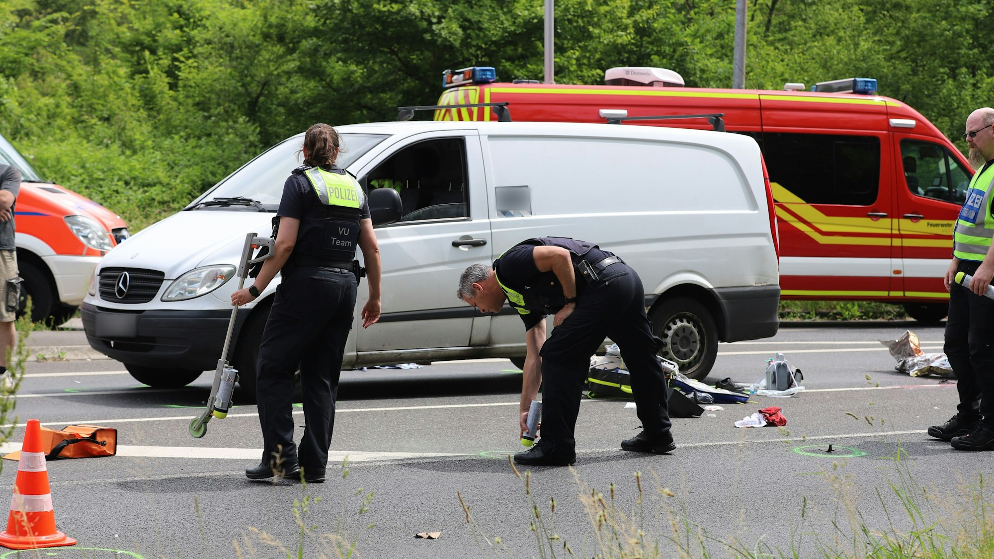 Einsatzkräfte sichern Spuren auf einer Fahrbahn.