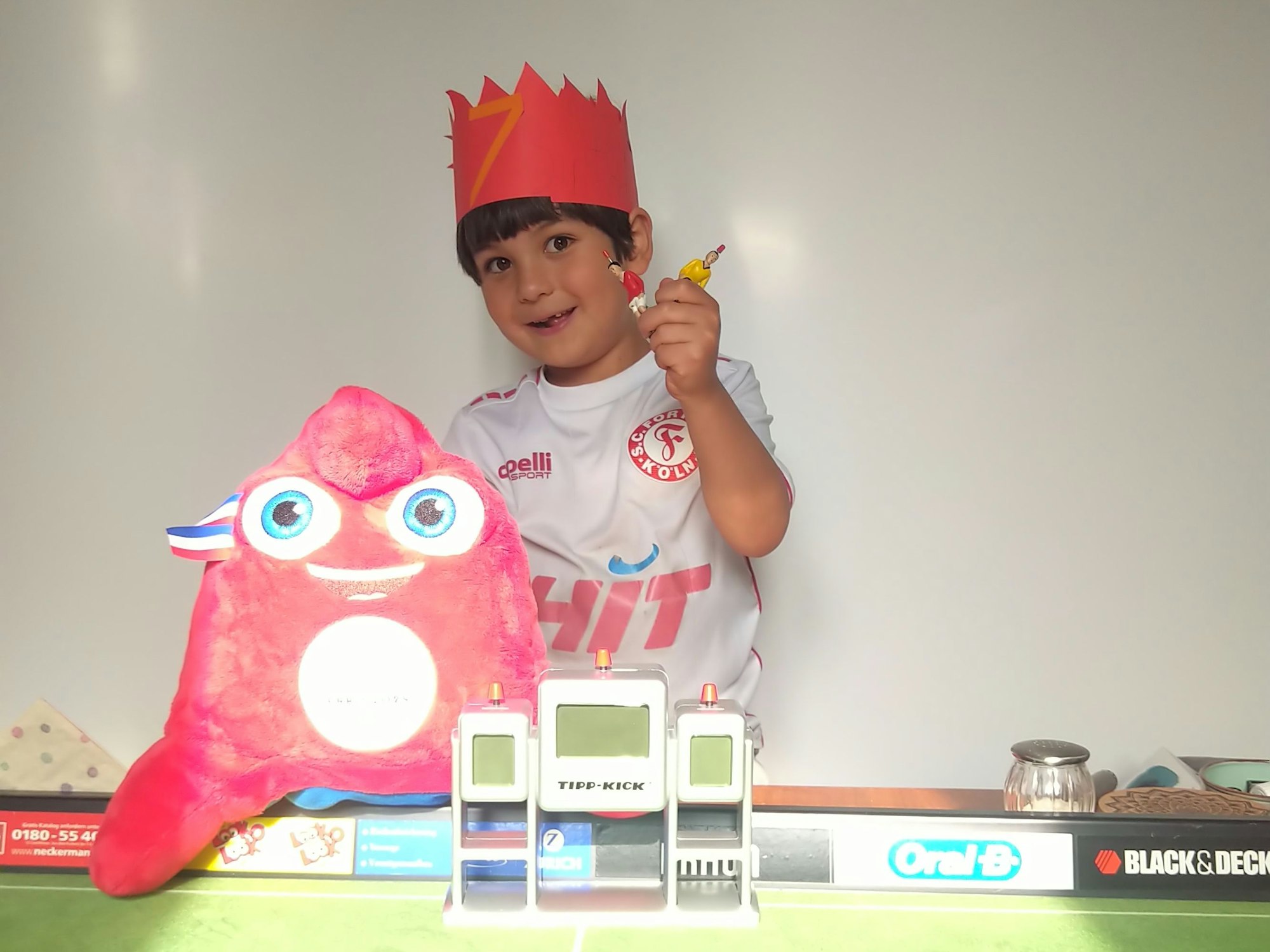 Ein Junge mit Krone und einem Plüschtier.